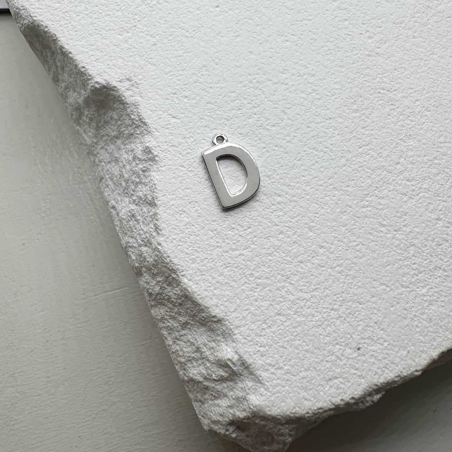 Inicialo pakabukas -  raidelė. Sidabras arba auksas