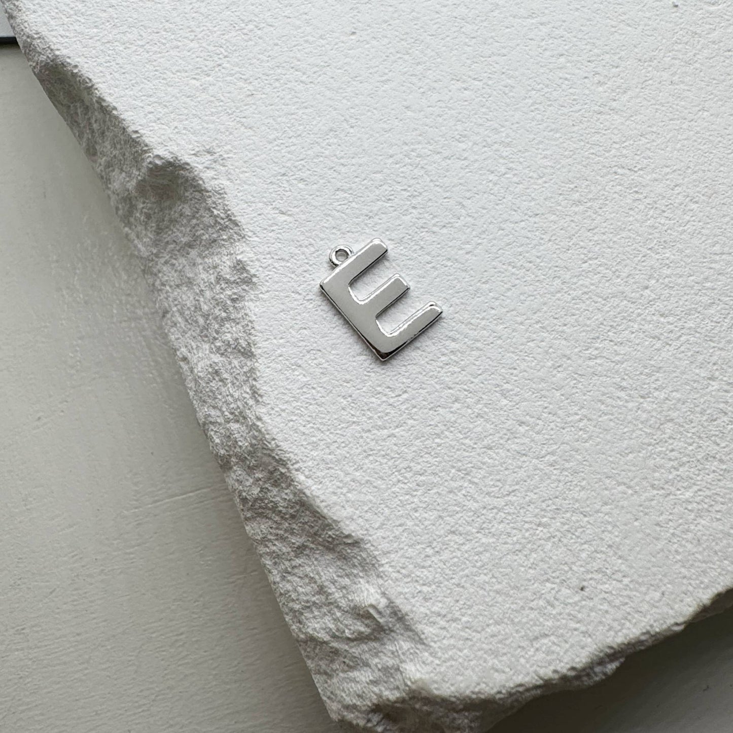 Inicialo pakabukas -  raidelė. Sidabras arba auksas