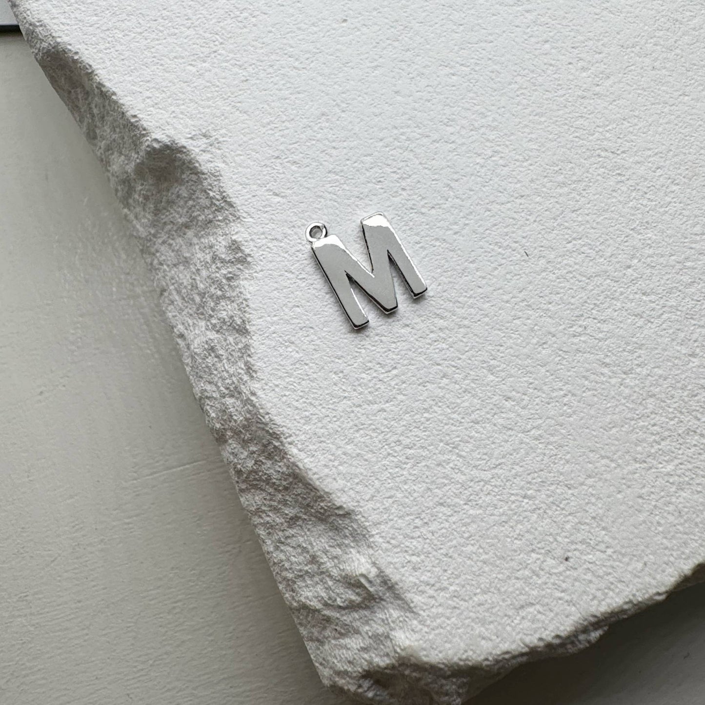 Inicialo pakabukas -  raidelė. Sidabras arba auksas