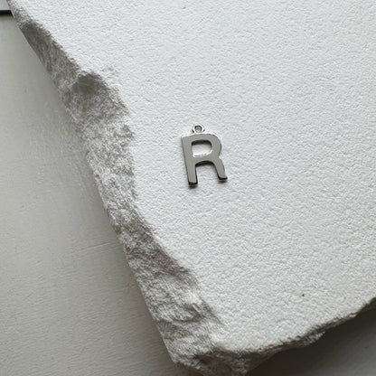 Inicialo pakabukas -  raidelė. Sidabras arba auksas