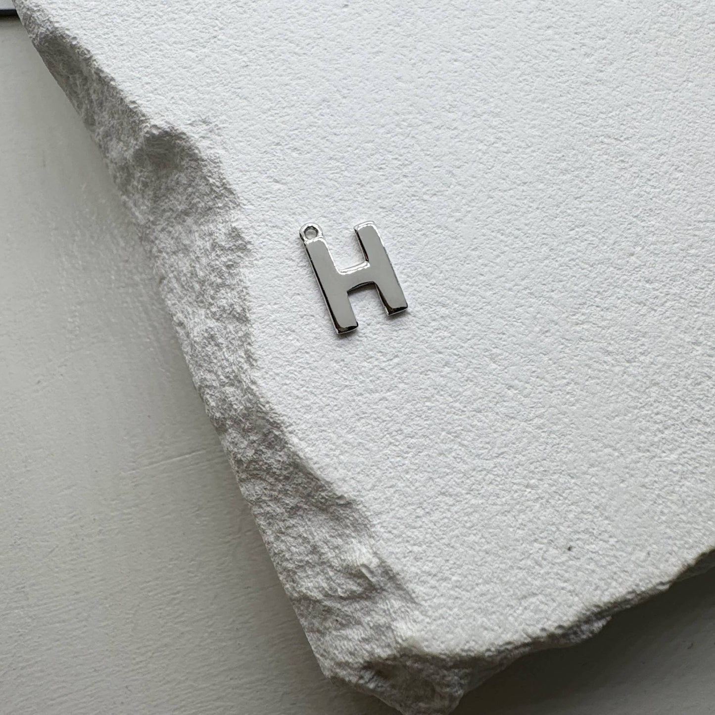 Inicialo pakabukas -  raidelė. Sidabras arba auksas