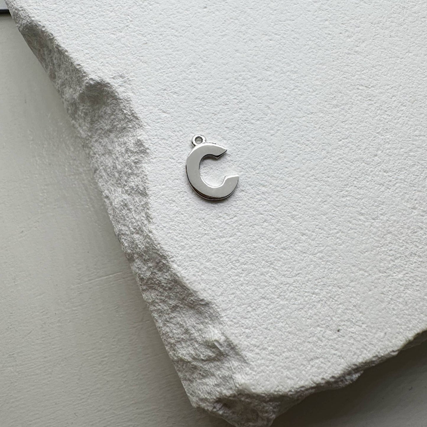 Inicialo pakabukas -  raidelė. Sidabras arba auksas